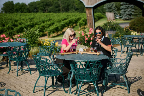 A couple enjoy a wine tasting in the vineyard at Hernder Estate Winery.